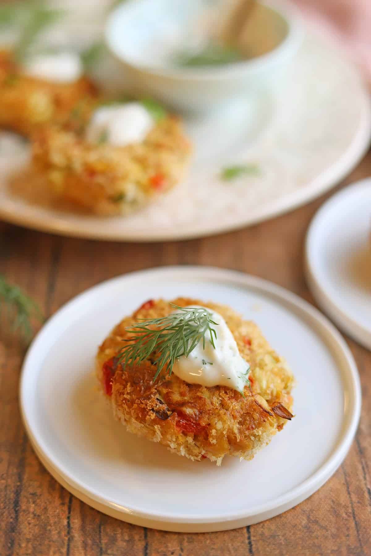 Artichoke chickpea crab cake with panko on plate with dollop of lemon dill aioli.