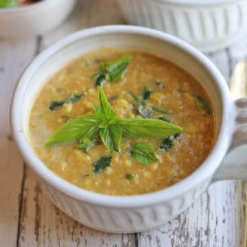 Bowl of smoky vegan corn chowder with fresh basil garnish.