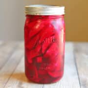 Hot pink pickled turnips in jar on table.