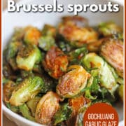 Text overlay: crispy pan-fried Brussels sprouts, gochujang garlic glaze, get the recipe at cadryskitchen.com." Fried Brussels sprouts with gochujang in bowl.