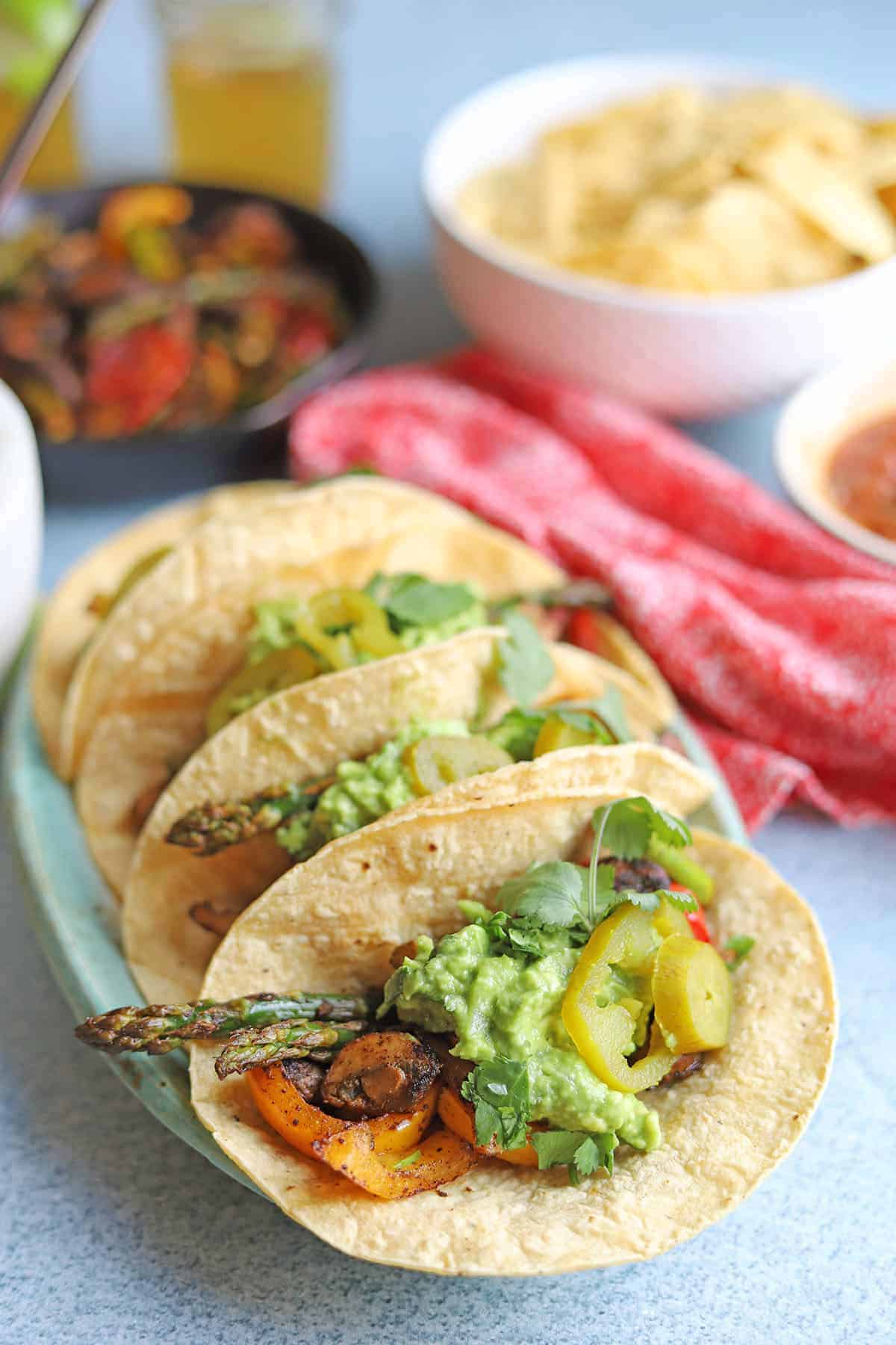Grilled vegetable fajitas in corn tortillas with asparagus, bell peppers, and mushrooms.