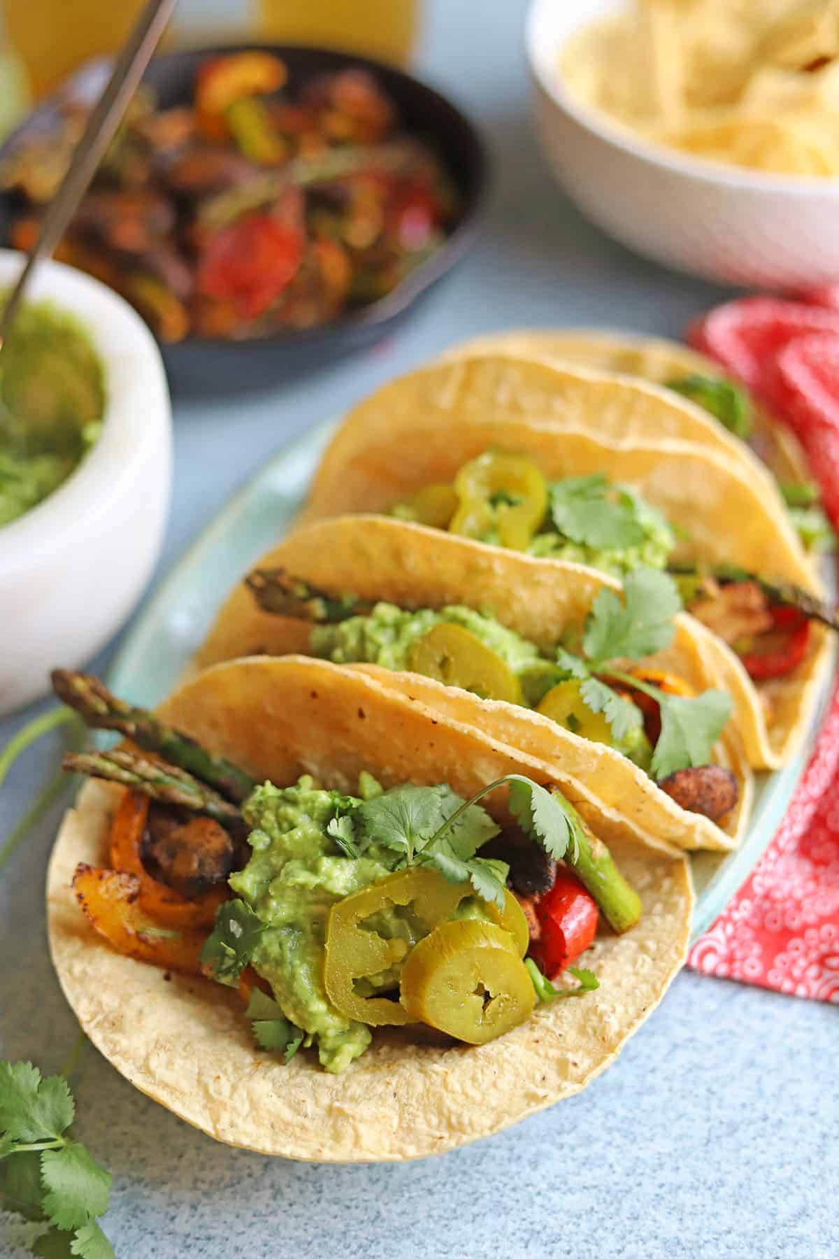 Platter with grilled vegetable fajitas with asparagus, mushrooms, and red bell pepper.