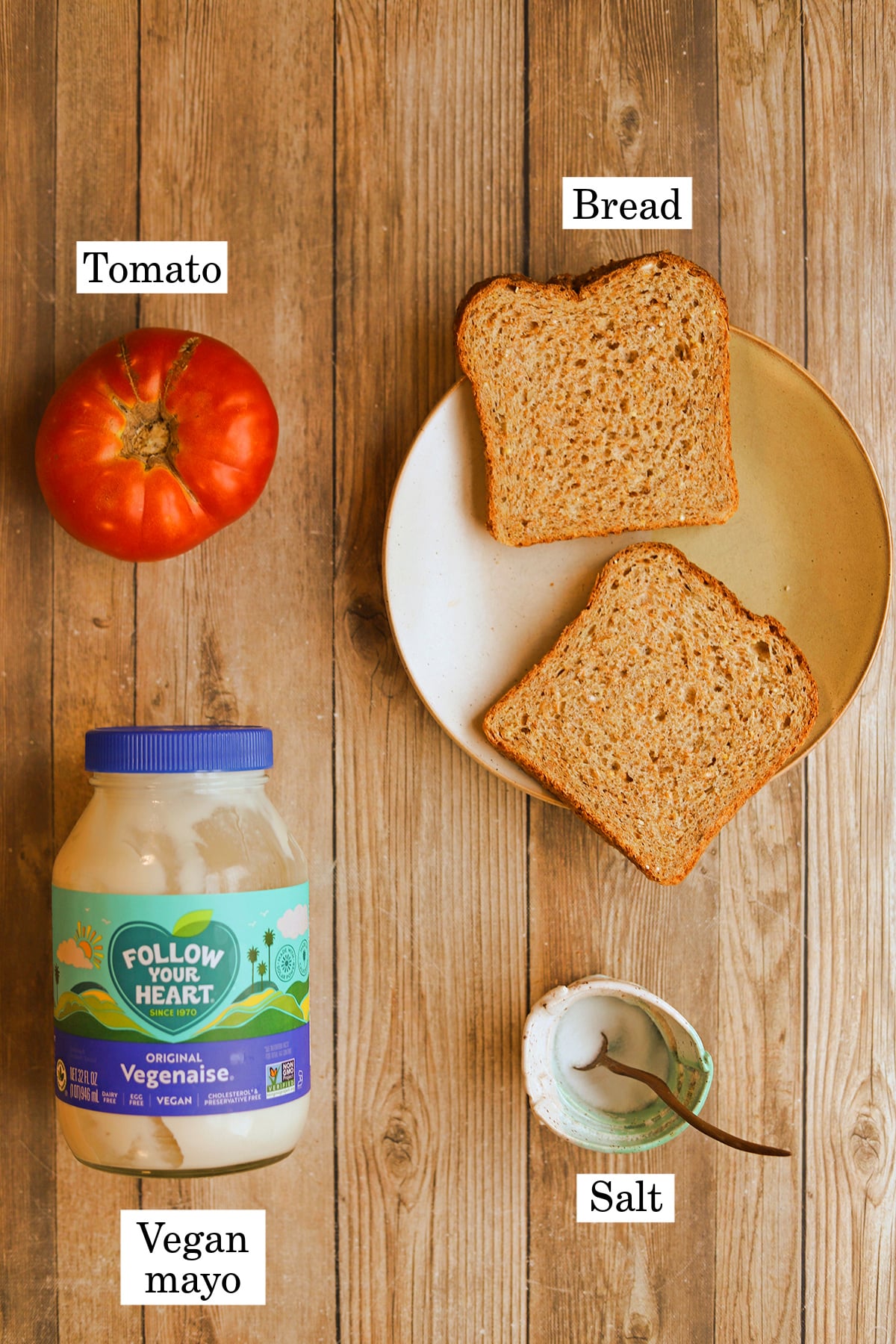 Labeled ingredients for vegan tomato sandwich - tomato, bread, vegan mayo, and salt.