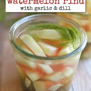 Text overlay: cadryskitchen.com, pickled watermelon rind with garlic & dill. Sliced watermelon rind in jar with fresh dill and garlic slices.