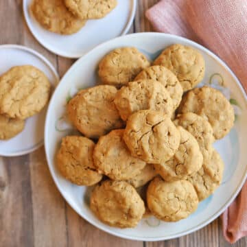 Egg-free and dairy-free peanut butter and oatmeal cookies on plates with napkin.