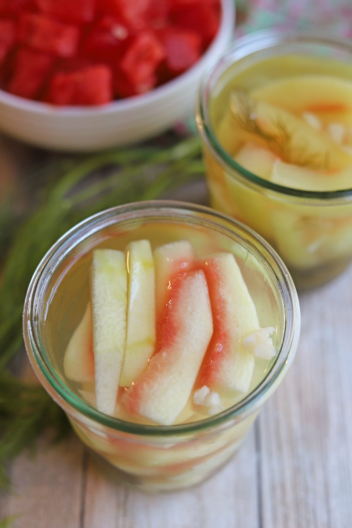 Yellow & pink watermelon pickles in brine with garlic.