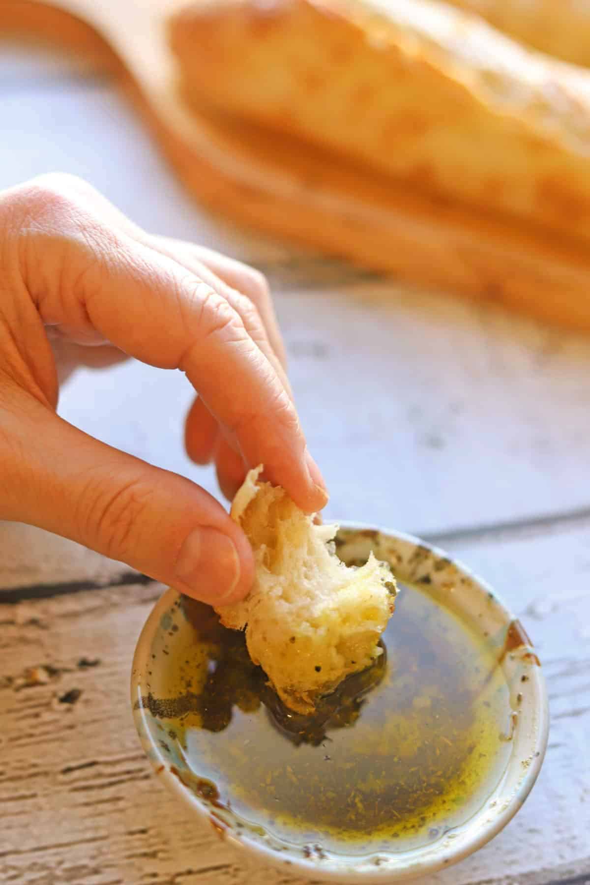 Bread being dunked into Italian-style restaurant bread dipping oil.
