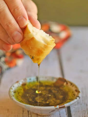 Seasoned oil dripping off of piece of bread.