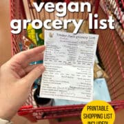 Text overlay: Trader Joe's vegan grocery list. Printable shopping list included. Get the list at cadryskitchen.com. Hand holding circled grocery list in front of Trader Joe's cart.