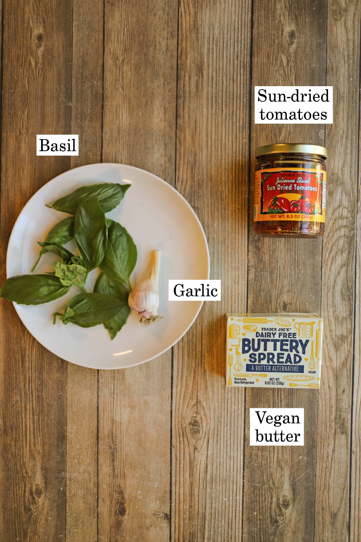 Labeled ingredients for vegan butter with fresh basil, garlic, sun-dried tomatoes.