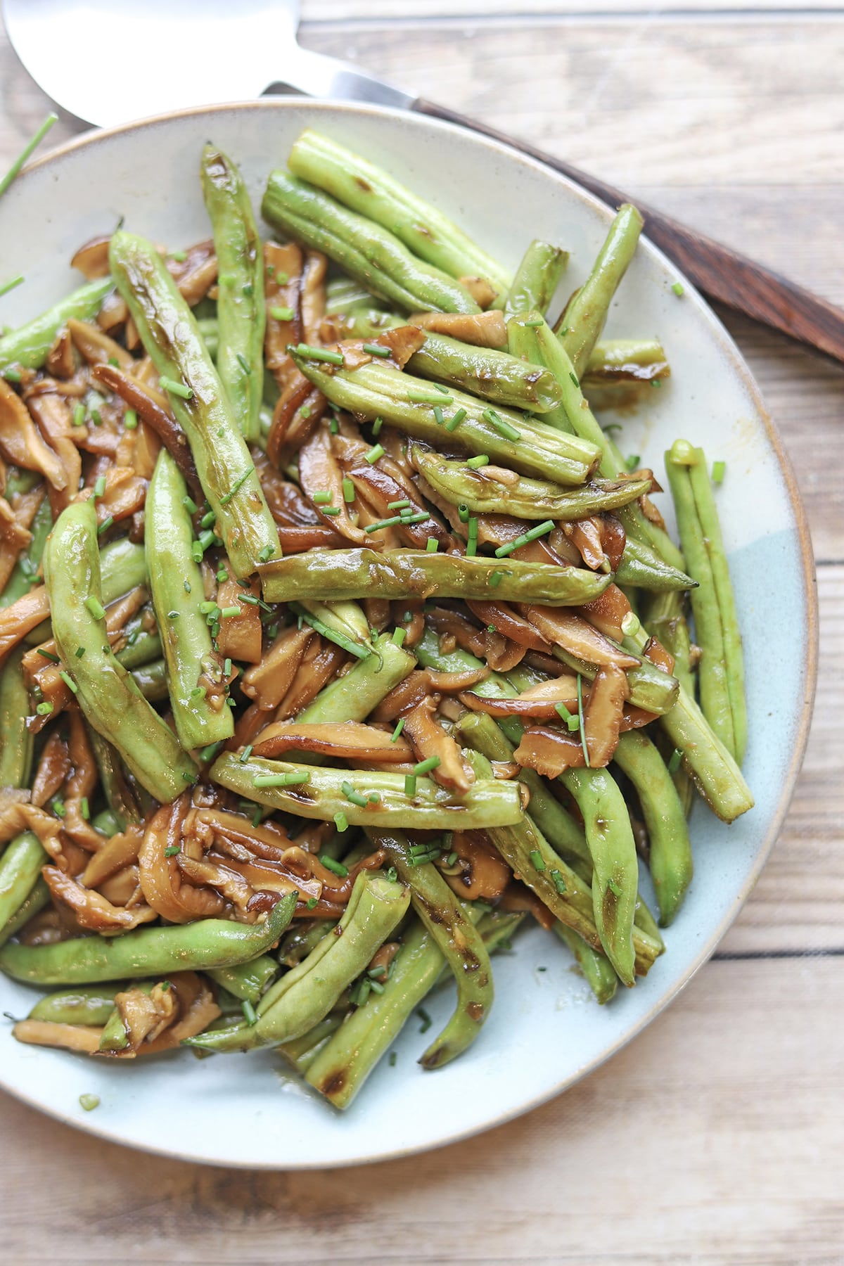 Plate with charred green beans and shiitake mushrooms in sesame soy sauce.