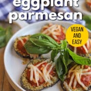 Text overlay: Air fryer eggplant parmesan, vegan and easy, get the recipe at cadryskitchen.com. Platter of breaded eggplant with vegan cheese and marinara.