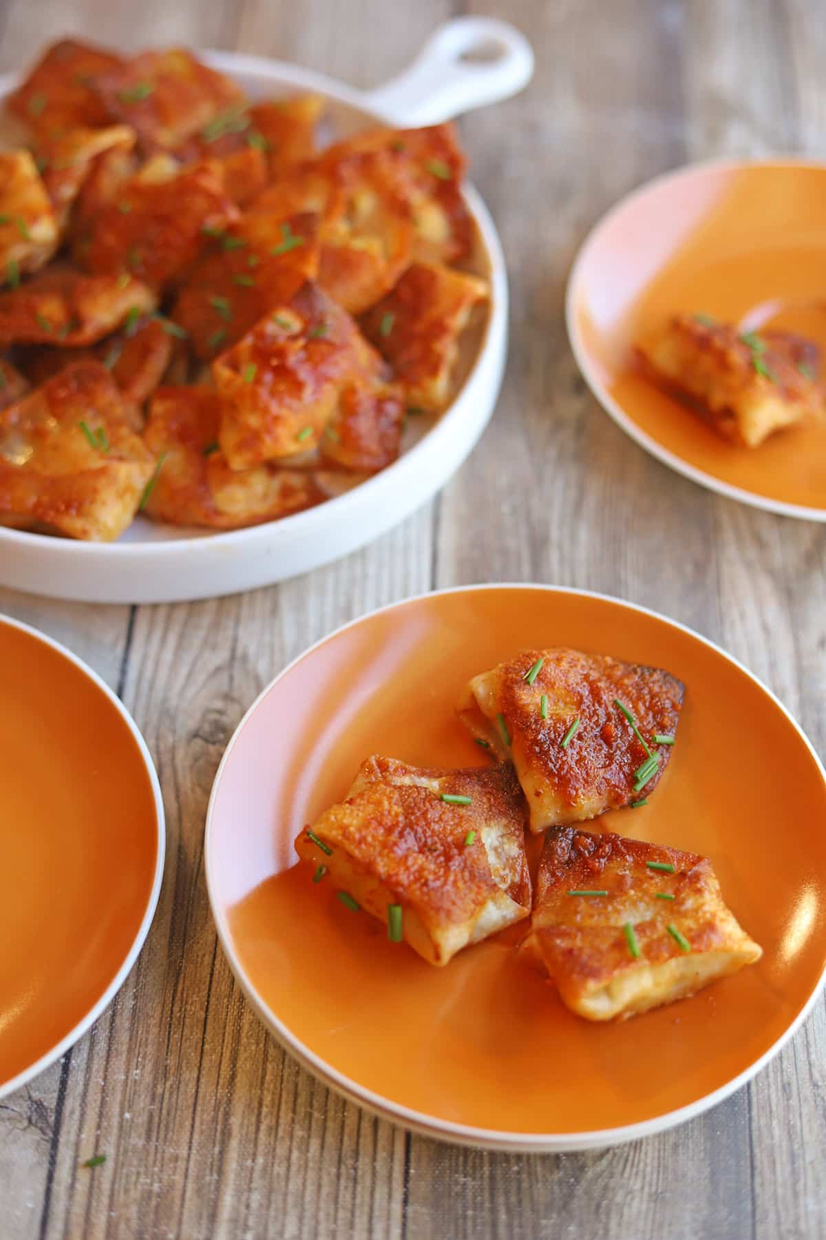 Fried tofu dumplings with chipotle adobo sauce on plates by serving dish.