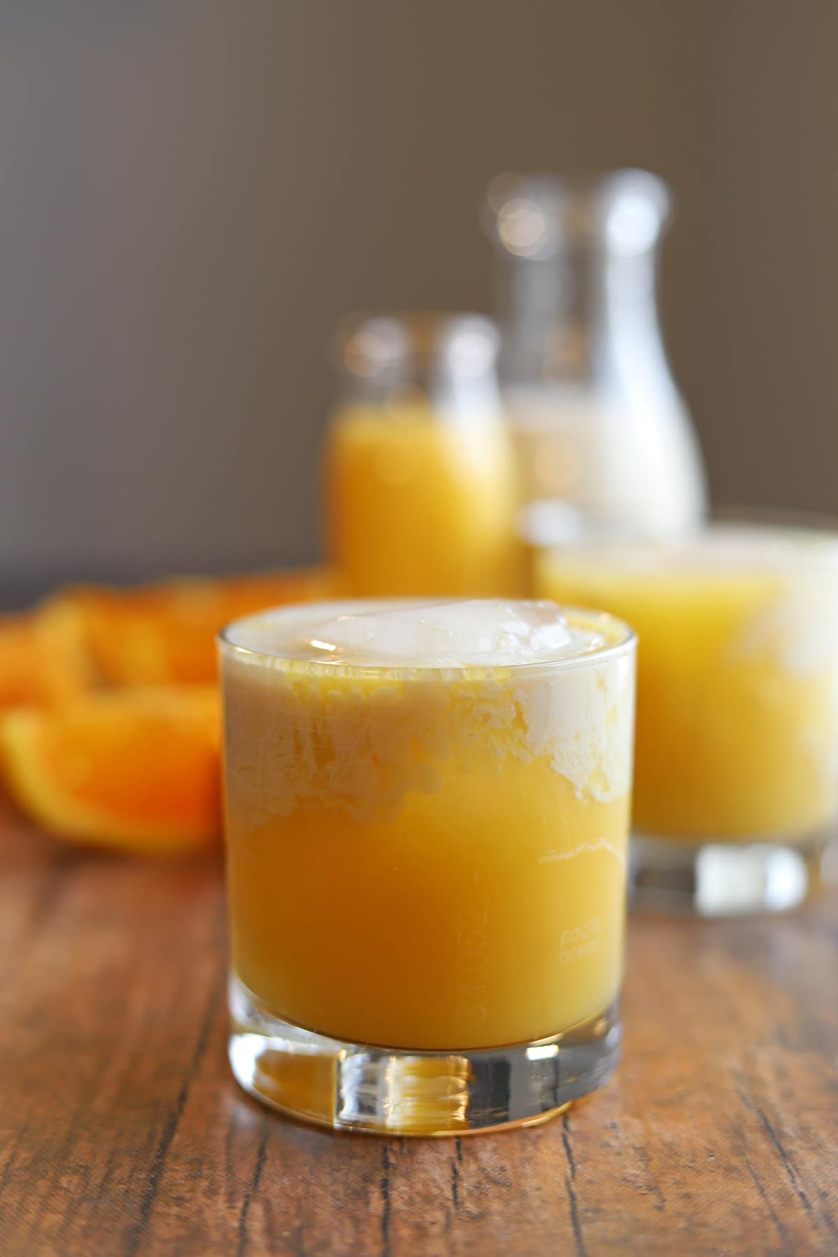 Orange creamsicle cocktail in glass with thin layer of sweetened vanilla almond milk on top.