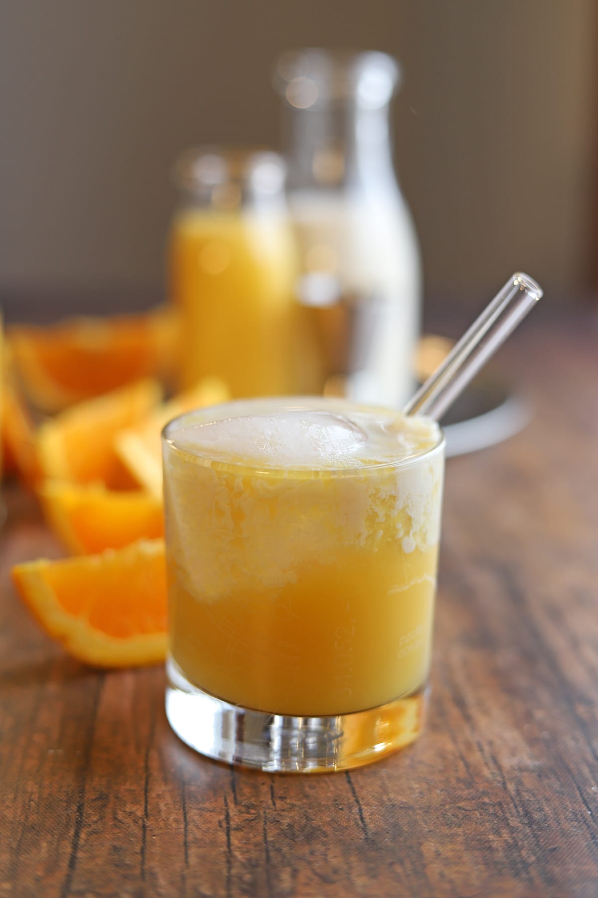 Orange creamsicle cocktail in glass with straw.