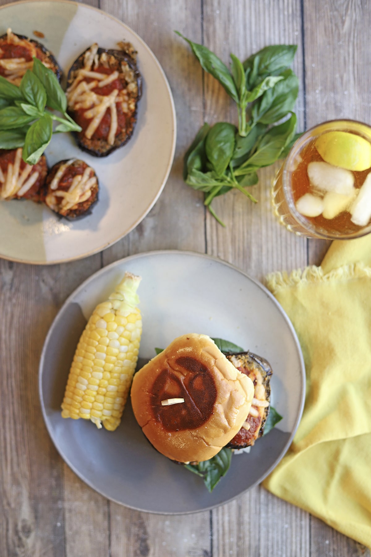 Vegan eggplant parm sandwich with tea and corn on the cob.