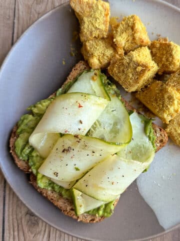 Ribbons of lemony zucchini on plate by seasoned tofu.