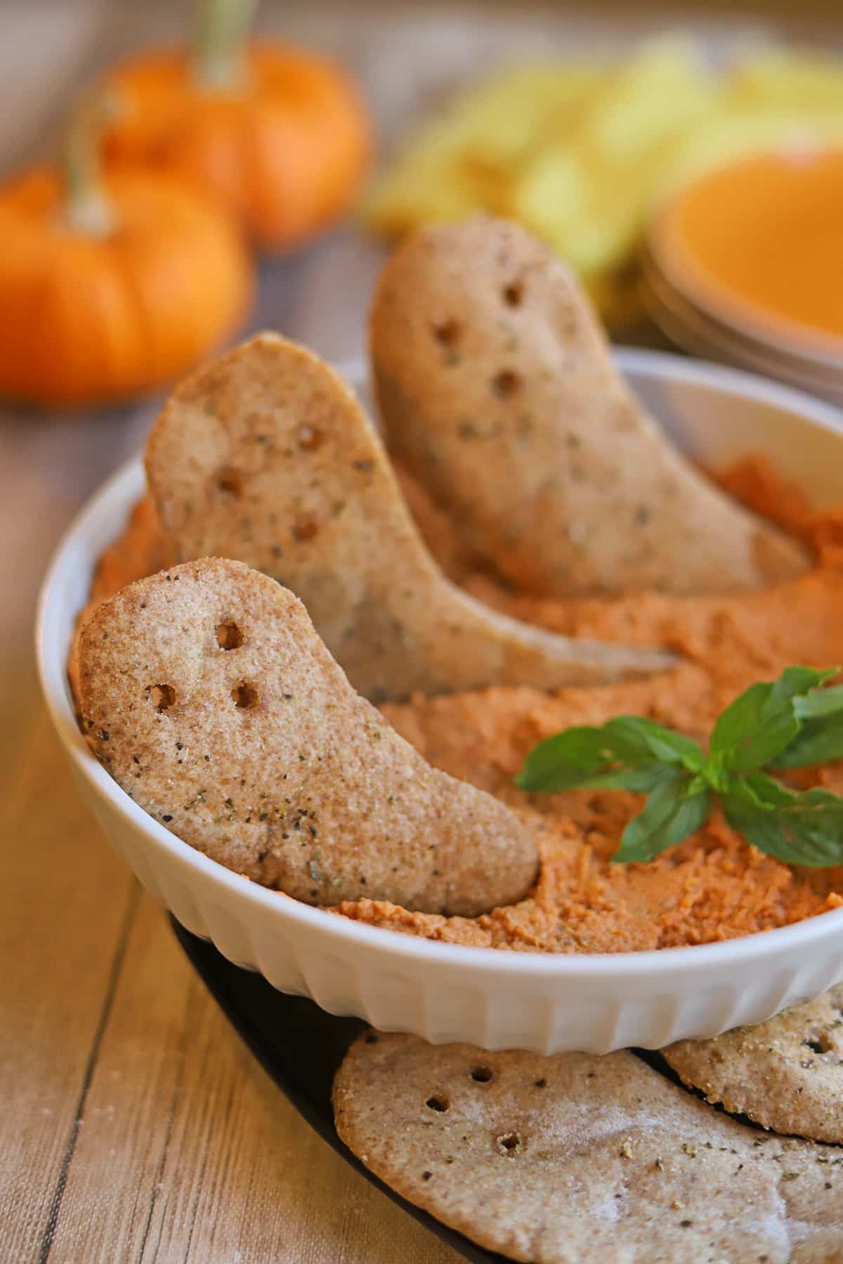 Air fried pita ghost chips in bowl of hummus.