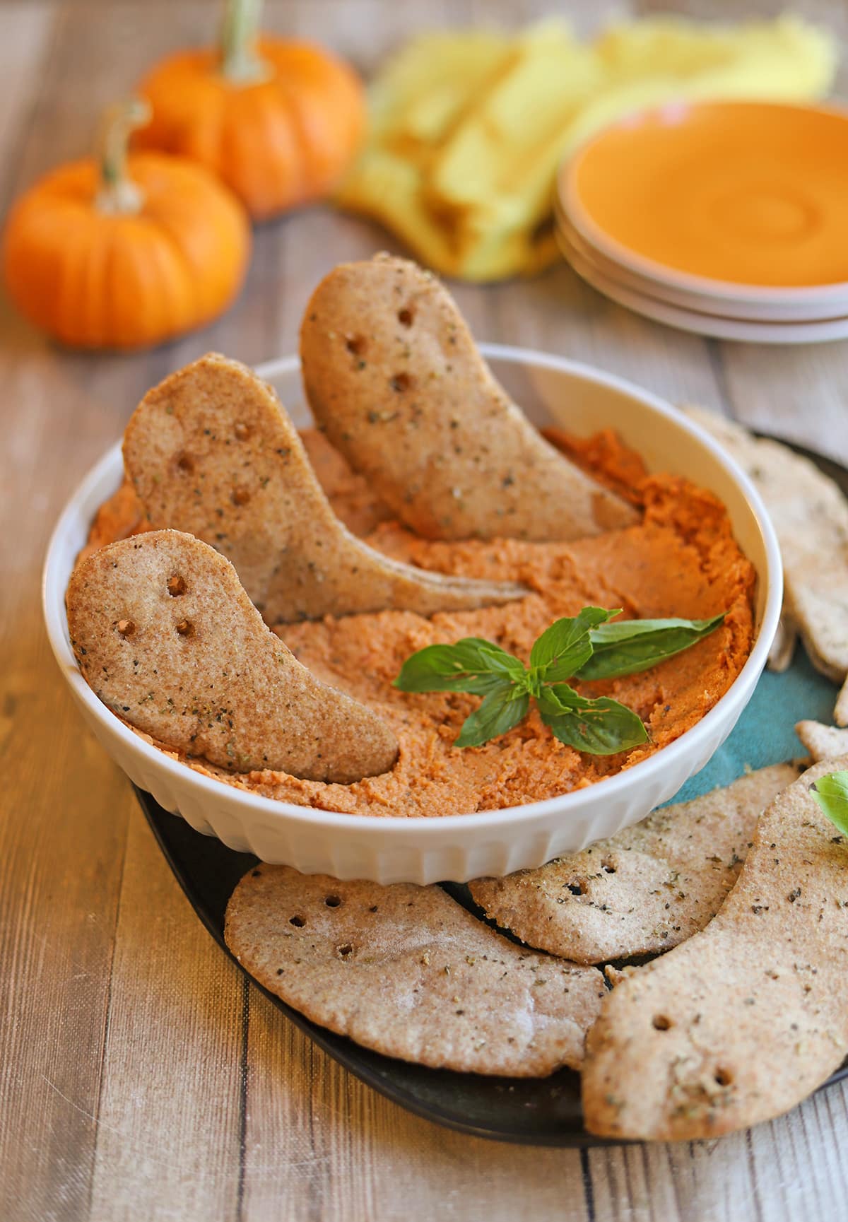 Vegan Halloween snacks of crispy pita chip ghosts and sun-dried tomato hummus.