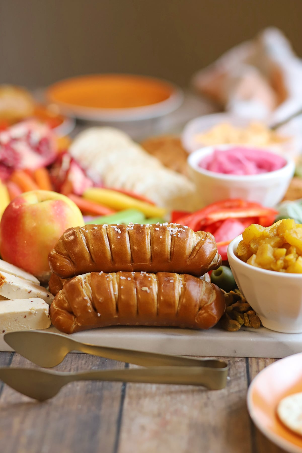 Soft pretzel sticks with kosher salt on fall snack board.