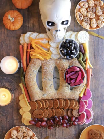 Vegan Halloween charcuterie board skeleton with pepperoni intestines, fougasse ribs, and turnip heart.