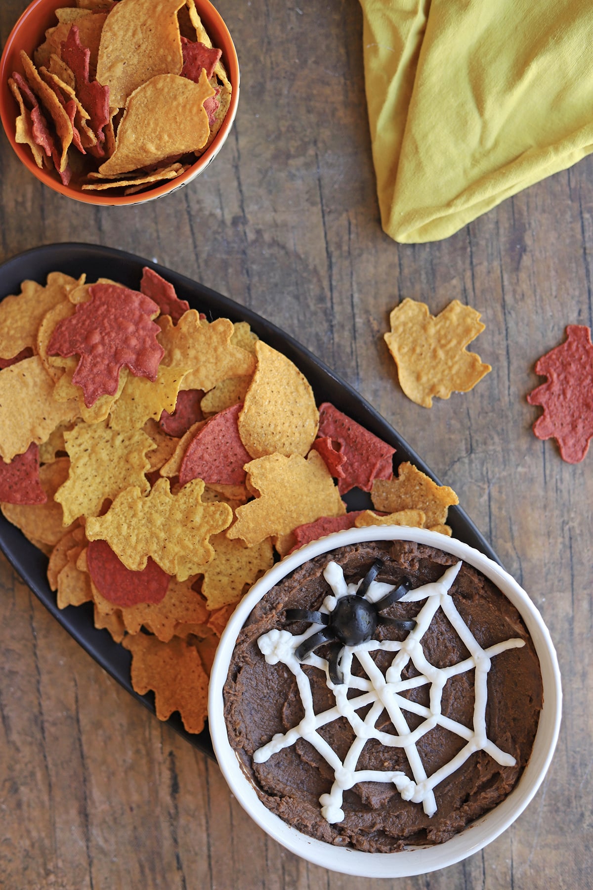 Halloween dip with spider web and spider and bowl of Trader Joe's leaf-shaped tortilla chips.