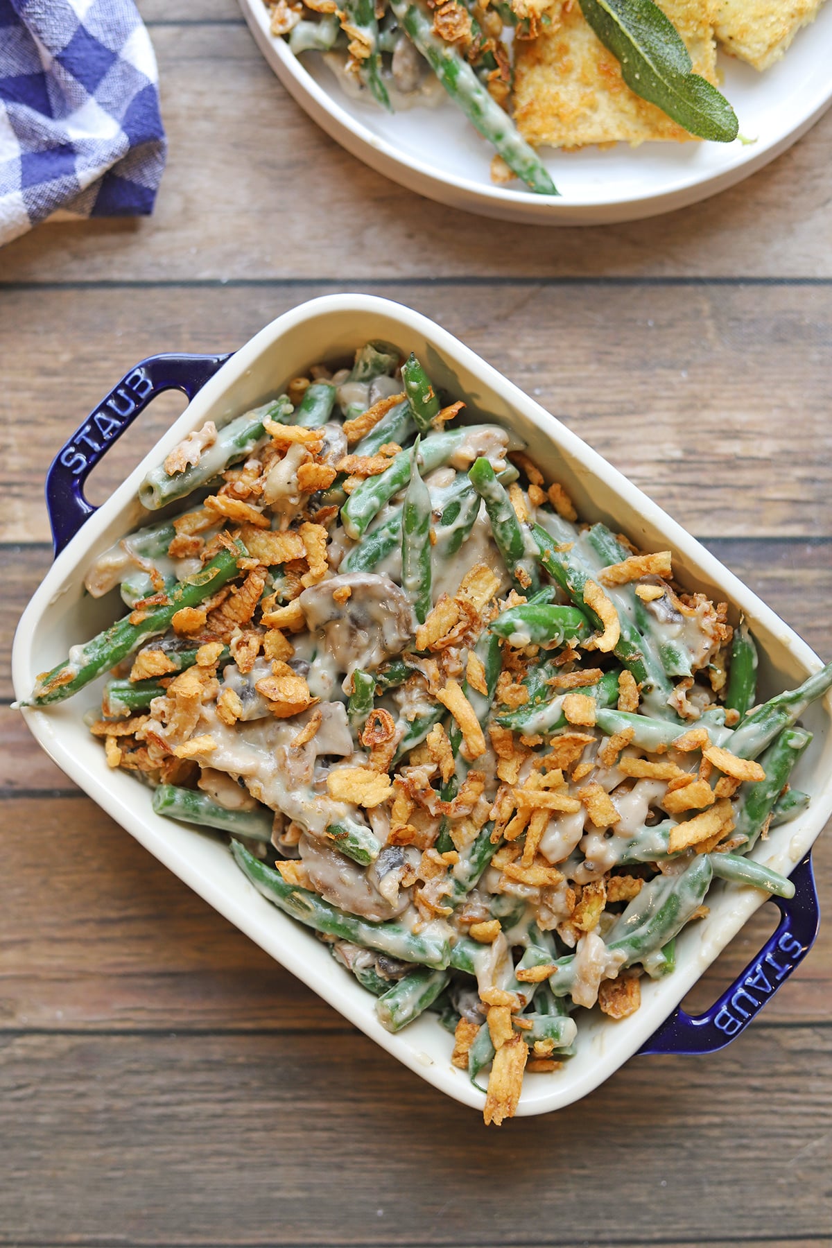 Green bean casserole with a cashew cream mushroom sauce, topped with fried onions.