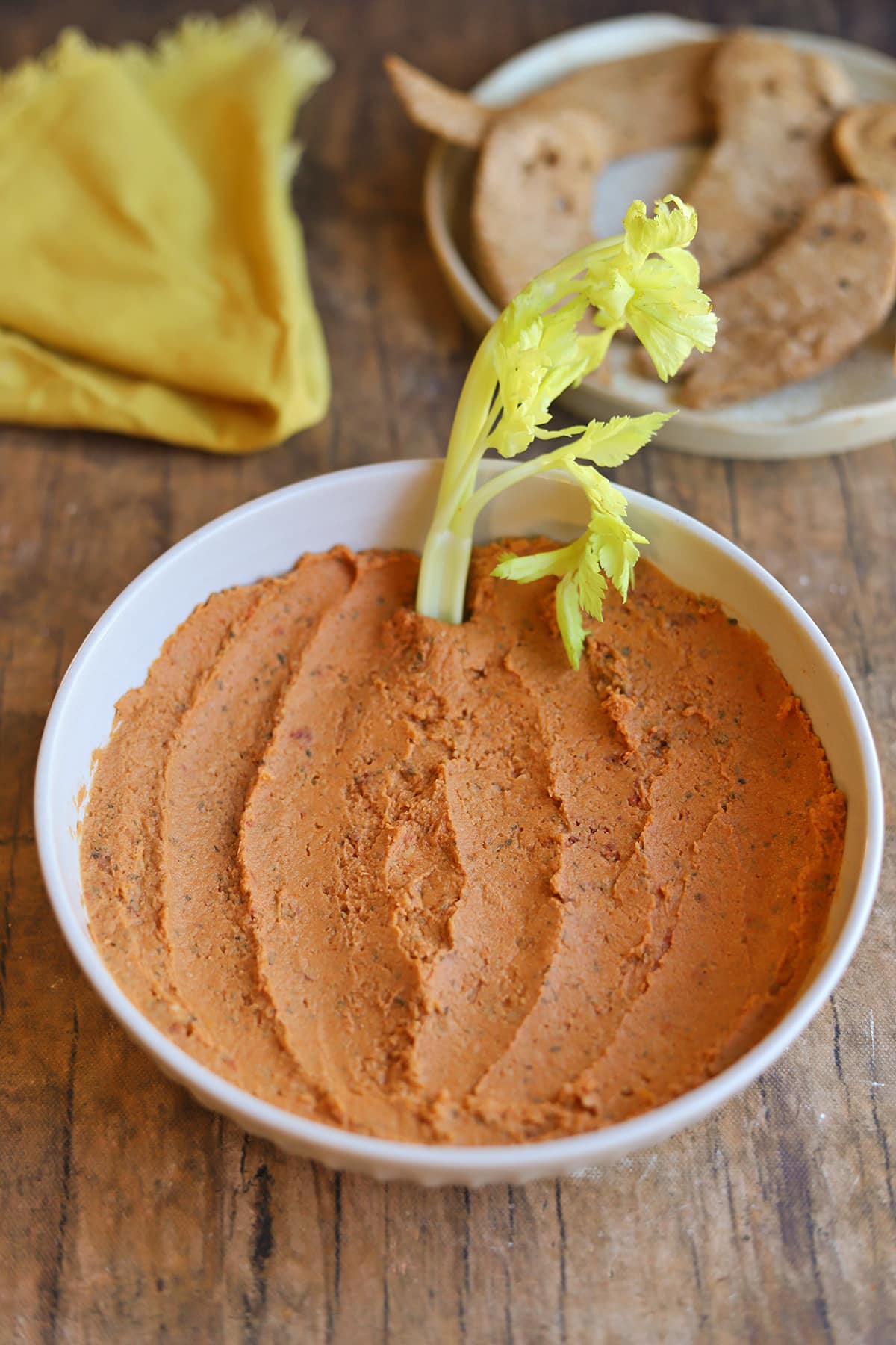 Sun-dried tomato hummus smeared into pumpkin shape with celery for a stem.