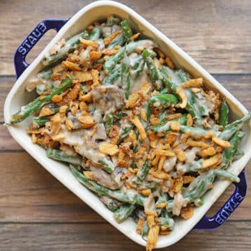 Vegan green bean casserole with mushrooms and cashew cream sauce topped with fried onions.