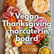 Text overlay: Vegan Thanksgiving charcuterie board, get the recipe at cadryskitchen.com. Vegan fall snack board with pepperoni, pimento cheese, mustard cheese, apple chutney, fruits, and vegetables.
