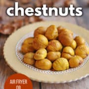 Text overlay: Roasted chestnuts, air fryer or oven baked, get the recipe at cadryskitchen.com. Plate of golden roasted chestnuts.