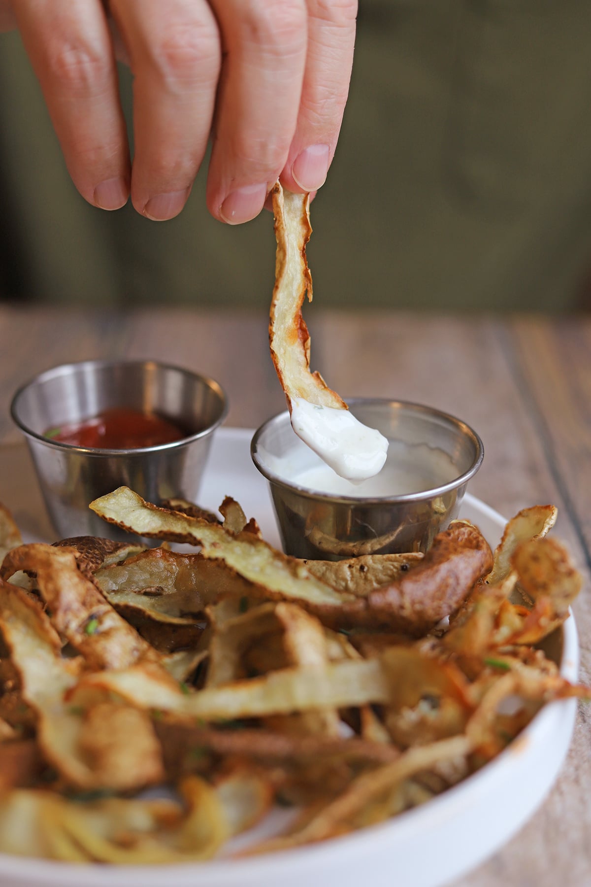Crispy air fried potato peel dunked in onion salad dressing.