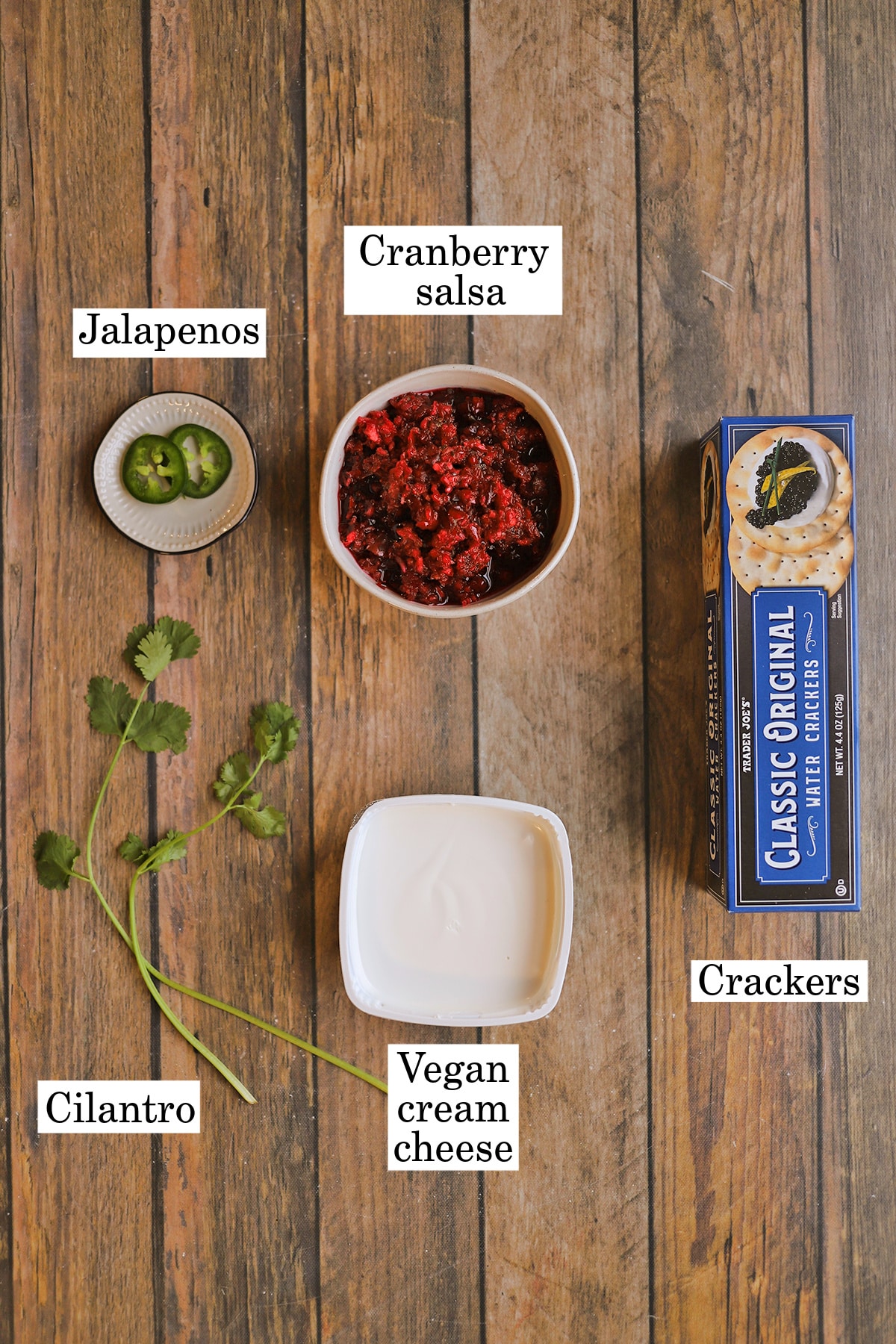 Labeled ingredients for cranberry salsa over vegan cream cheese with cilantro and jalapenos garnish.