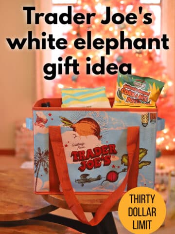 Text overlay: Trader Joe's white elephant gift idea, thirty dollar limit, cadryskitchen.com. Trader Joe's bag filled with snacks and treats in front of pink Christmas tree.