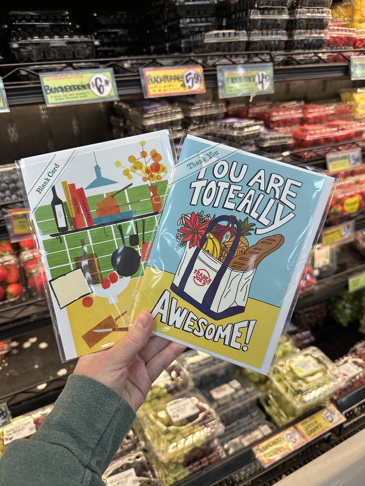 Hand holding cards from Trader Joe's - you are tote-ally awesome and modern kitchen scene.