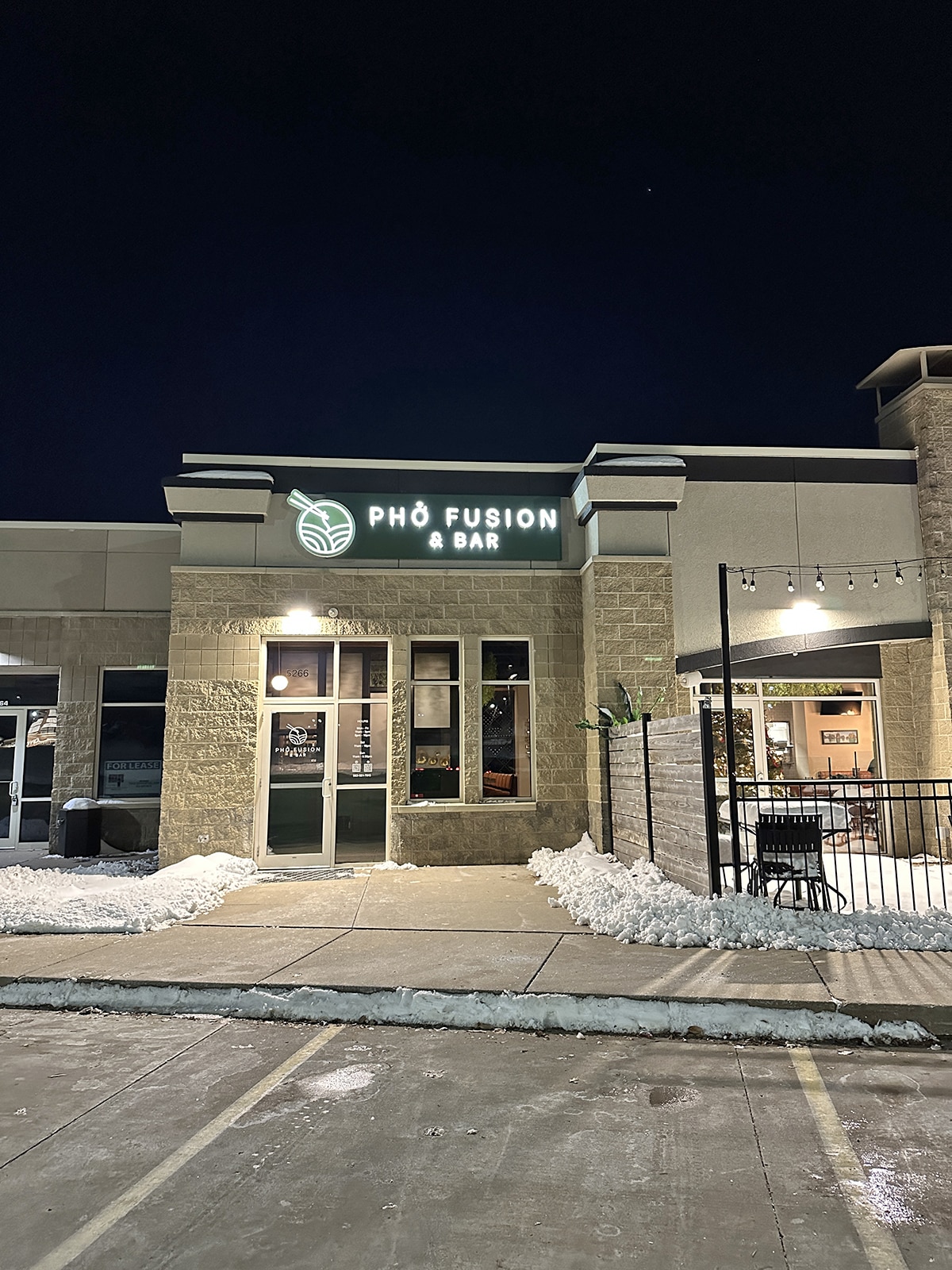 Exterior Pho Fusion and Bar in Davenport, Iowa at night, covered in snow.