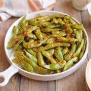 Platter of spicy edamame coated in a vegan chili crisp mayo sauce.