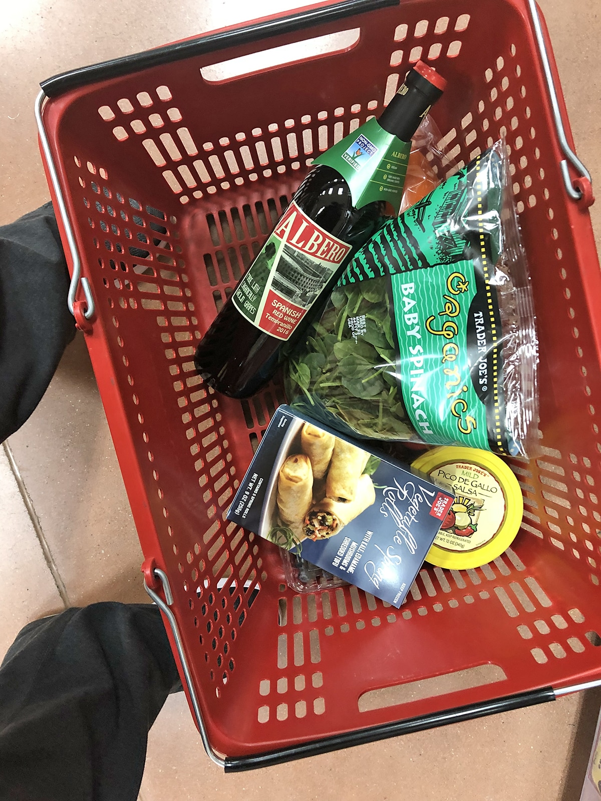 Bottle of Albero wine in basket with baby spinach, vegetable spring rolls, and pico de gallo.