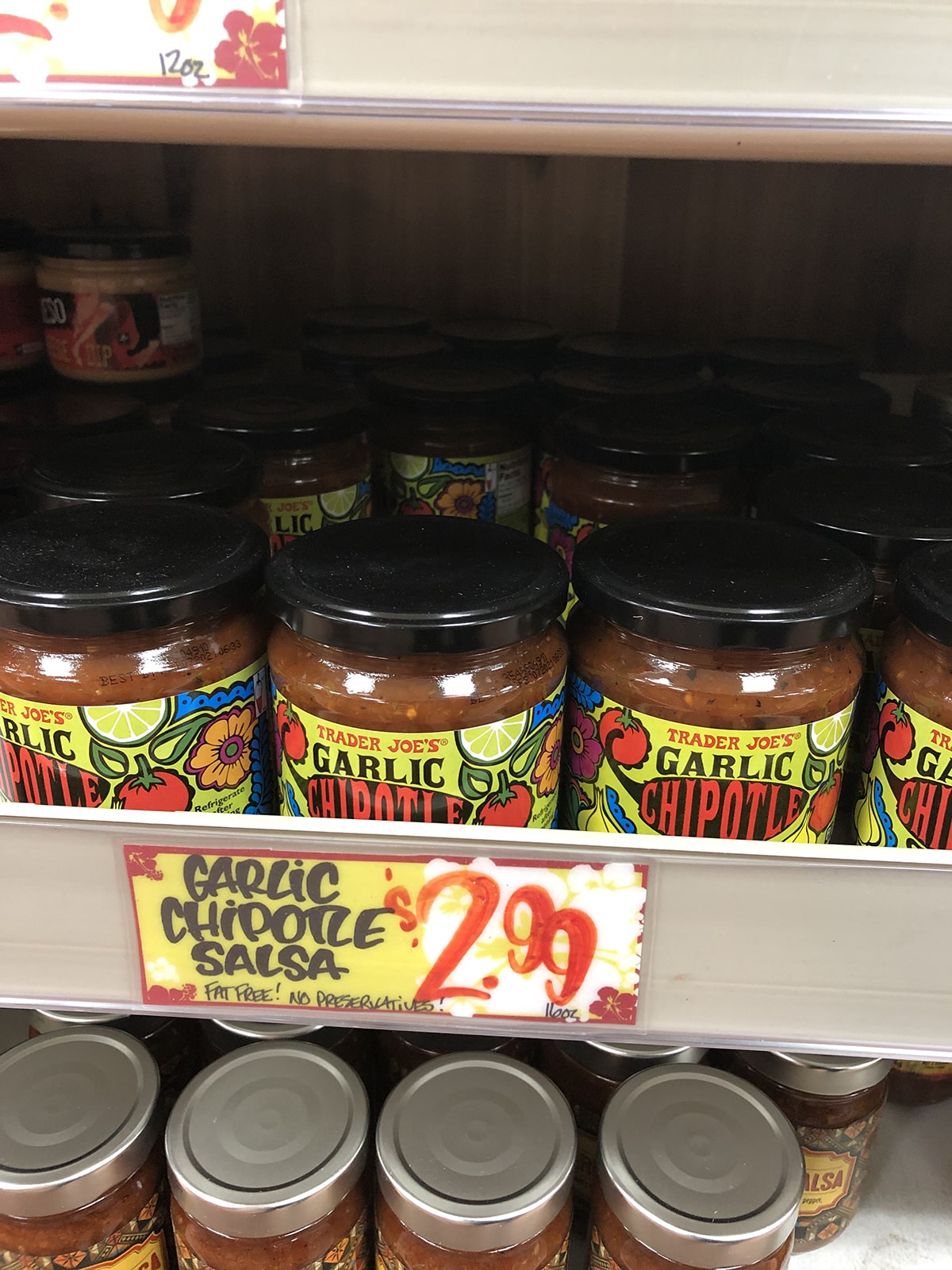 Jars of garlic chipotle salsa on store shelf at Trader Joe's.