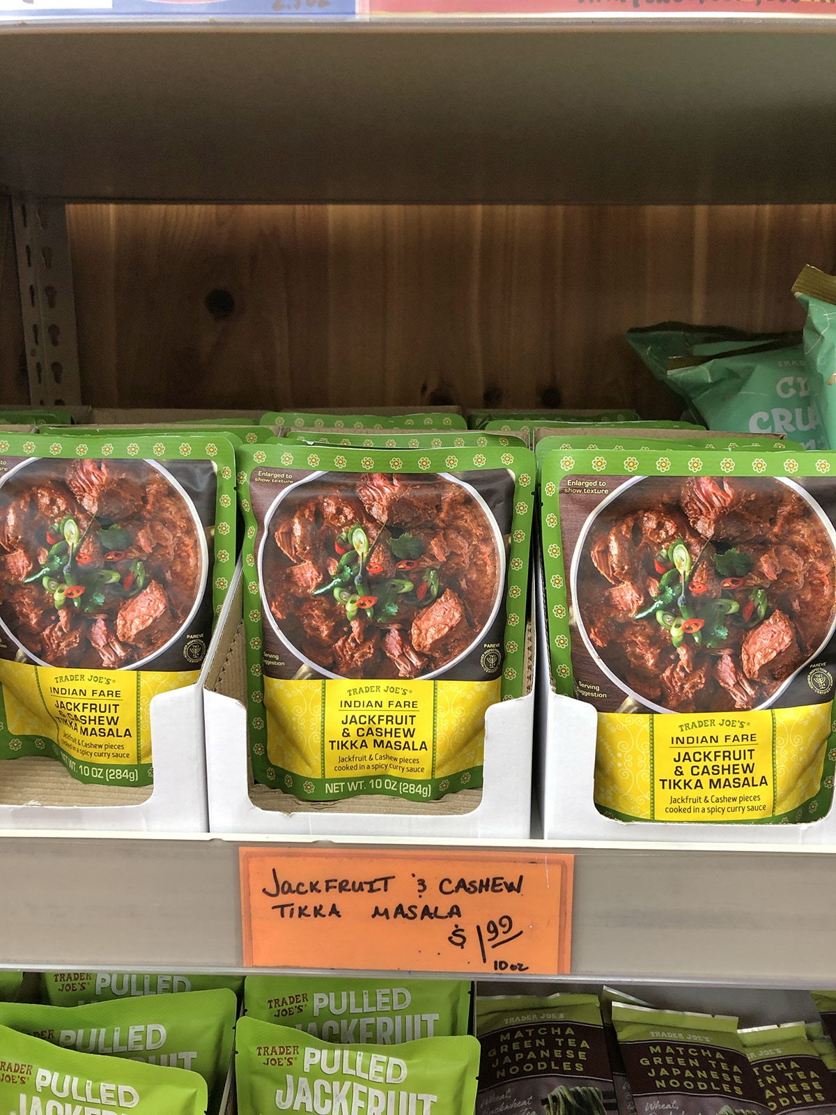 Shelf stable packages of jackfruit and cashew tikka masala on store shelf at Trader Joe's.