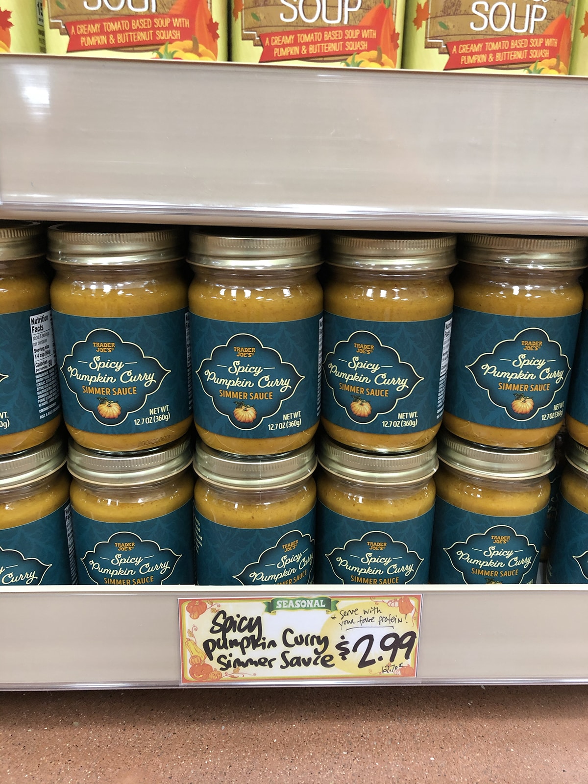 Bottles of spicy pumpkin curry on shelf at Trader Joe's.