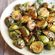 Chili crisp sauce clinging to air fried Brussels sprouts on plate.