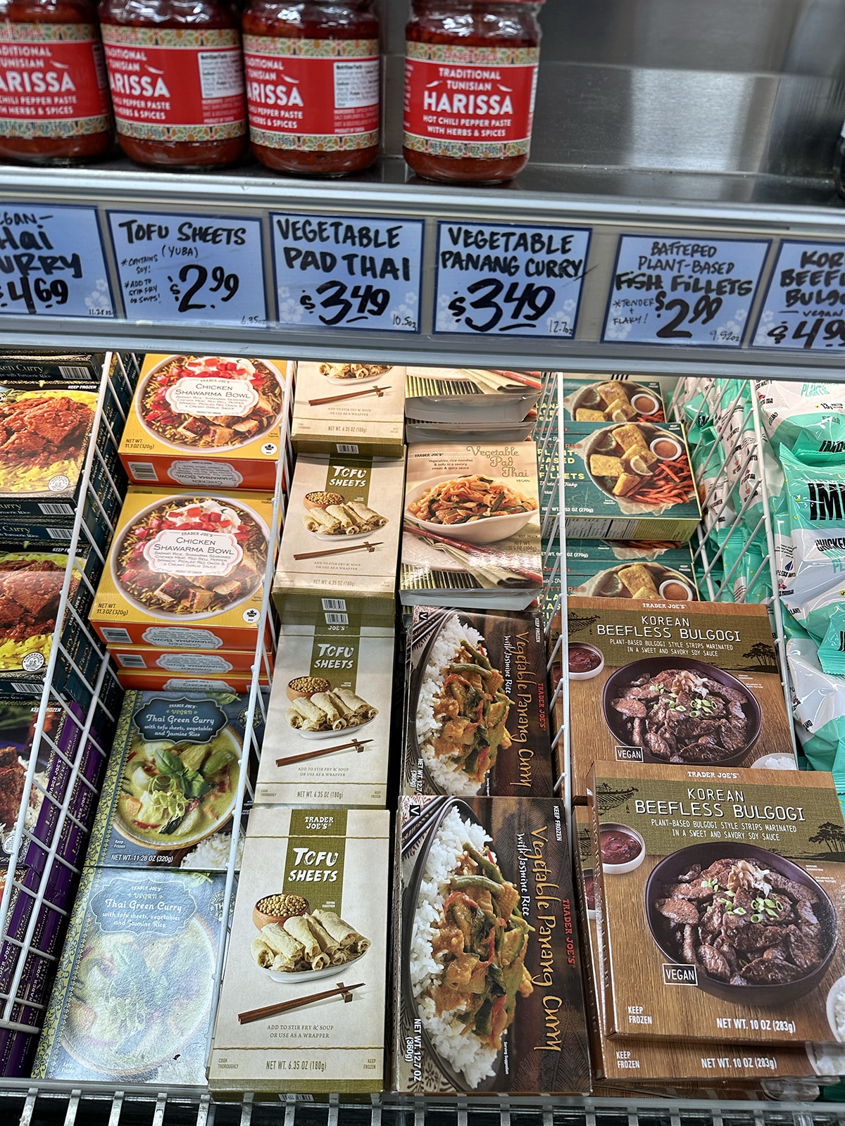 Tofu sheets in freezer case with Thai green curry, vegetable panang curry, beefless bulgogi, and plant-based fish filets.