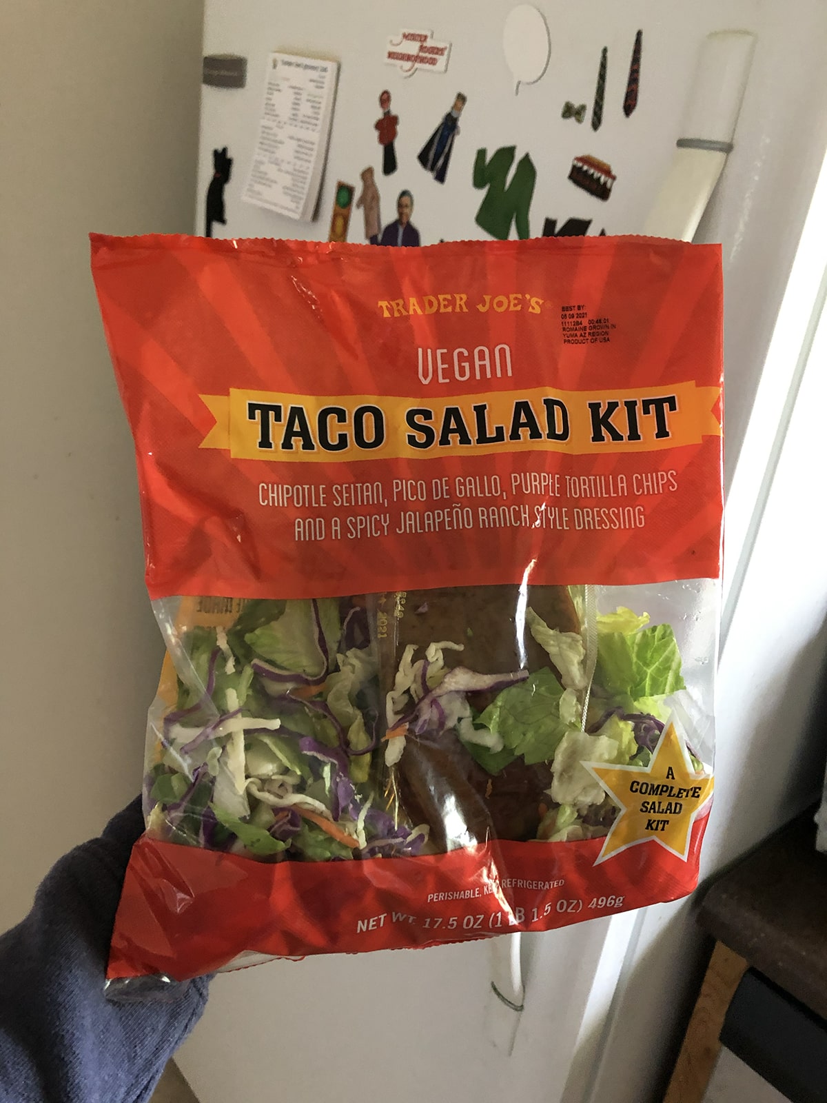 Trader Joe's vegan taco salad kit in front of refrigerator.