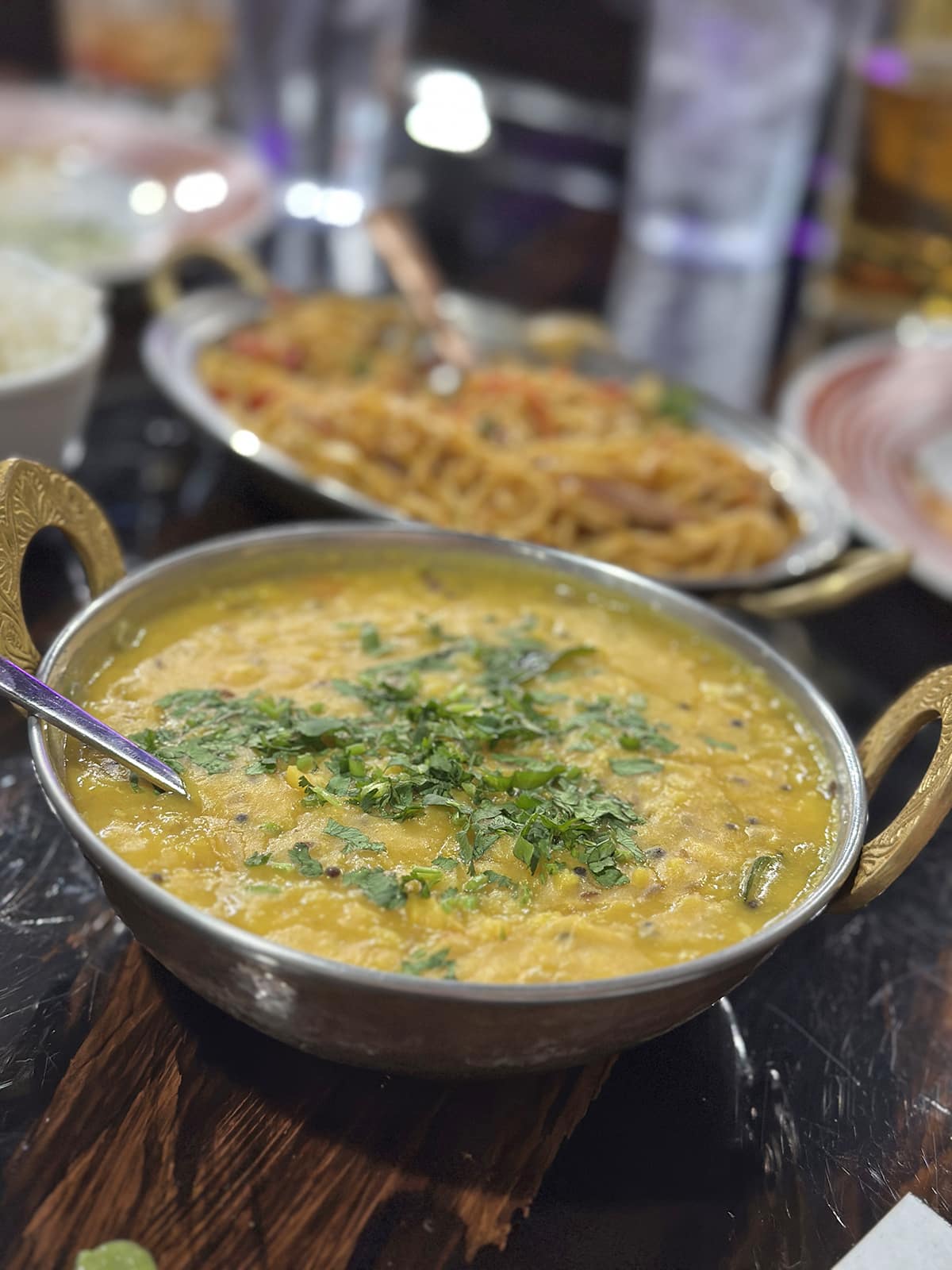 Dal tadka with cilantro garnish in metal bowl.