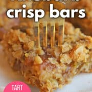 Text overlay: Rhubarb crisp bars. Tart, tangy, sweet. cadryskitchen.com. Close-up gooey rhubarb bar with fork speared into it.