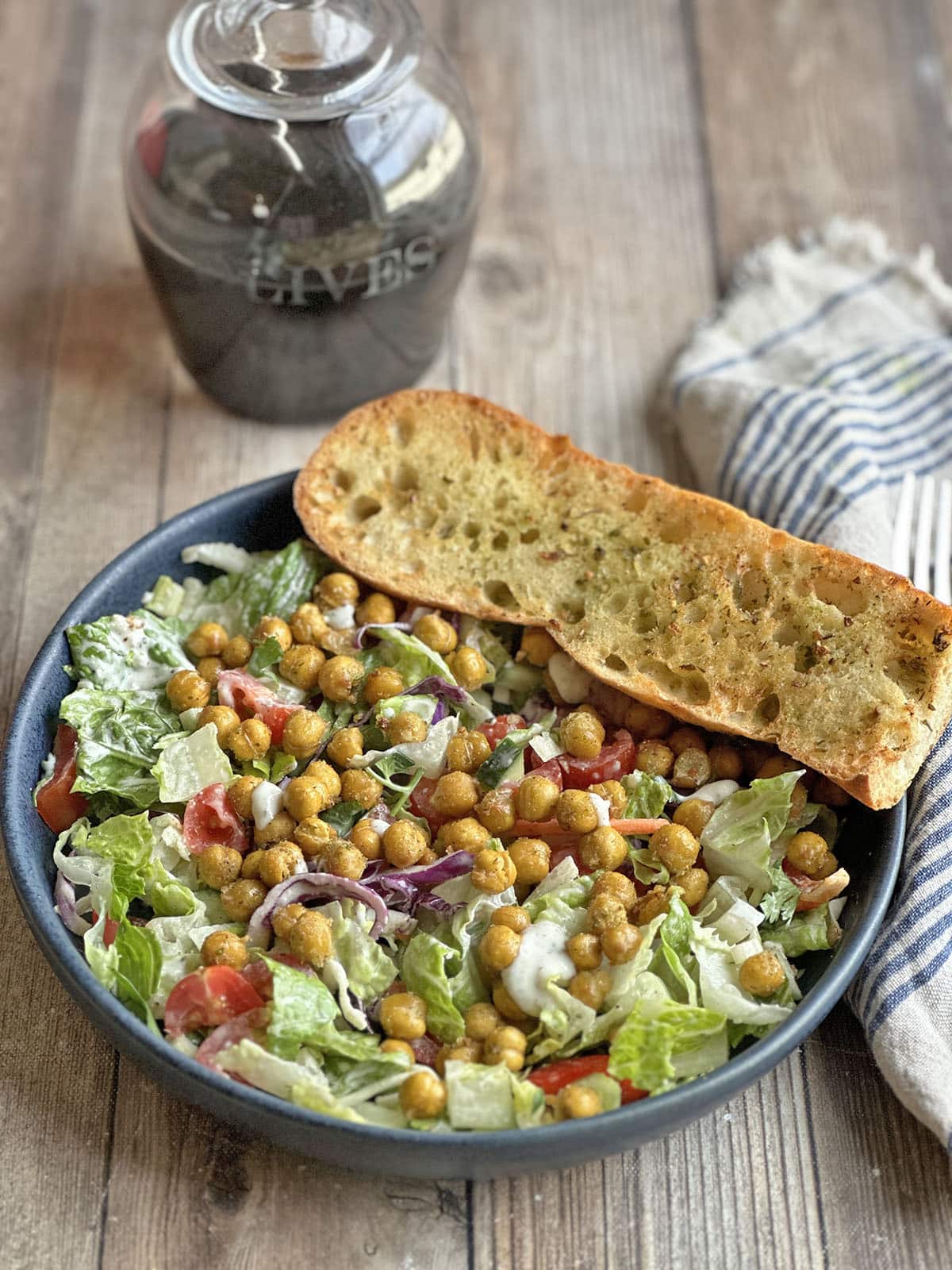 Crispy air fried garlic bread with seasoning salt on salad with roasted chickpeas.