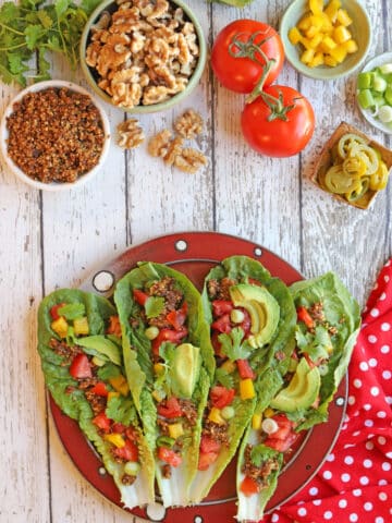 Vegan raw tacos with walnut filling, tomatoes, bell pepper, green onion, and tomatoes.