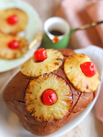 Vegan ham roast with pineapple brown sugar glaze, roasted pineapple rings, and maraschino cherries.