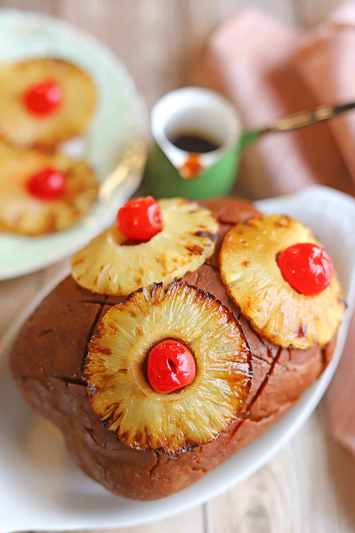 Vegan ham roast with pineapple brown sugar glaze, roasted pineapple rings, and maraschino cherries.